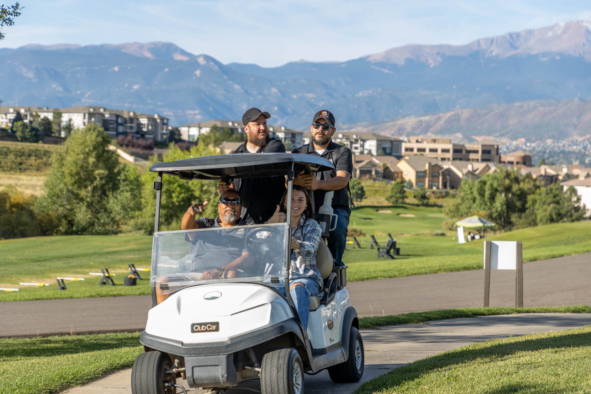Fred Ramirez of Apache Electric - Colorado Springs - A group of people riding in a golf cart on a golf course.