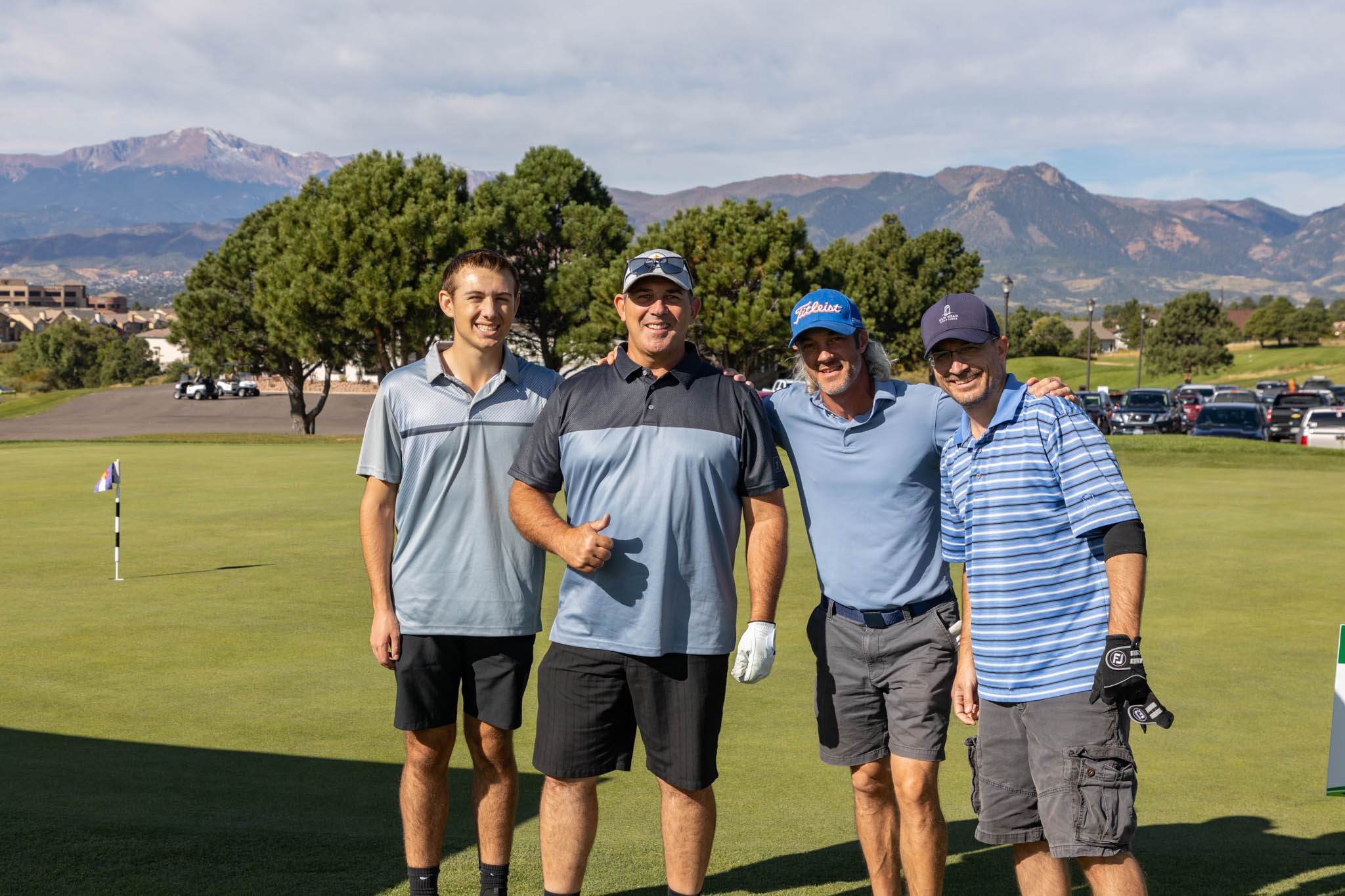 Steve Fisher, Garrett Fisher and two men posing for a photo on a golf course at Heartland Connect Golf Tournament at Pine Creek Golf Club in Colorado Springs