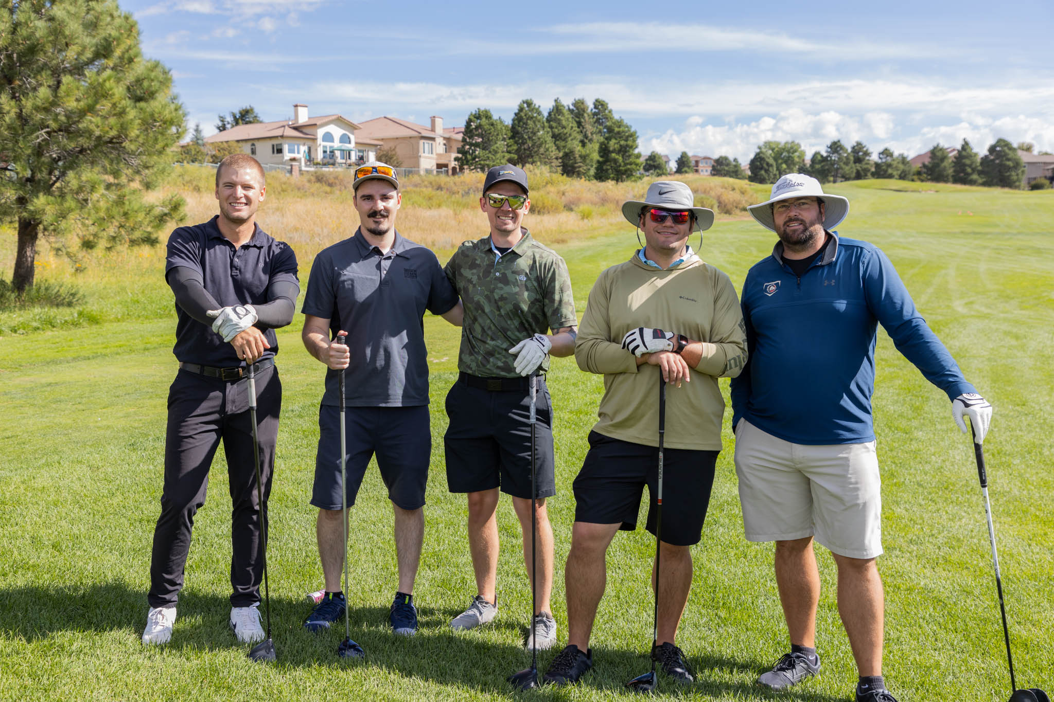 A group of men posing for a photo on a golf course.